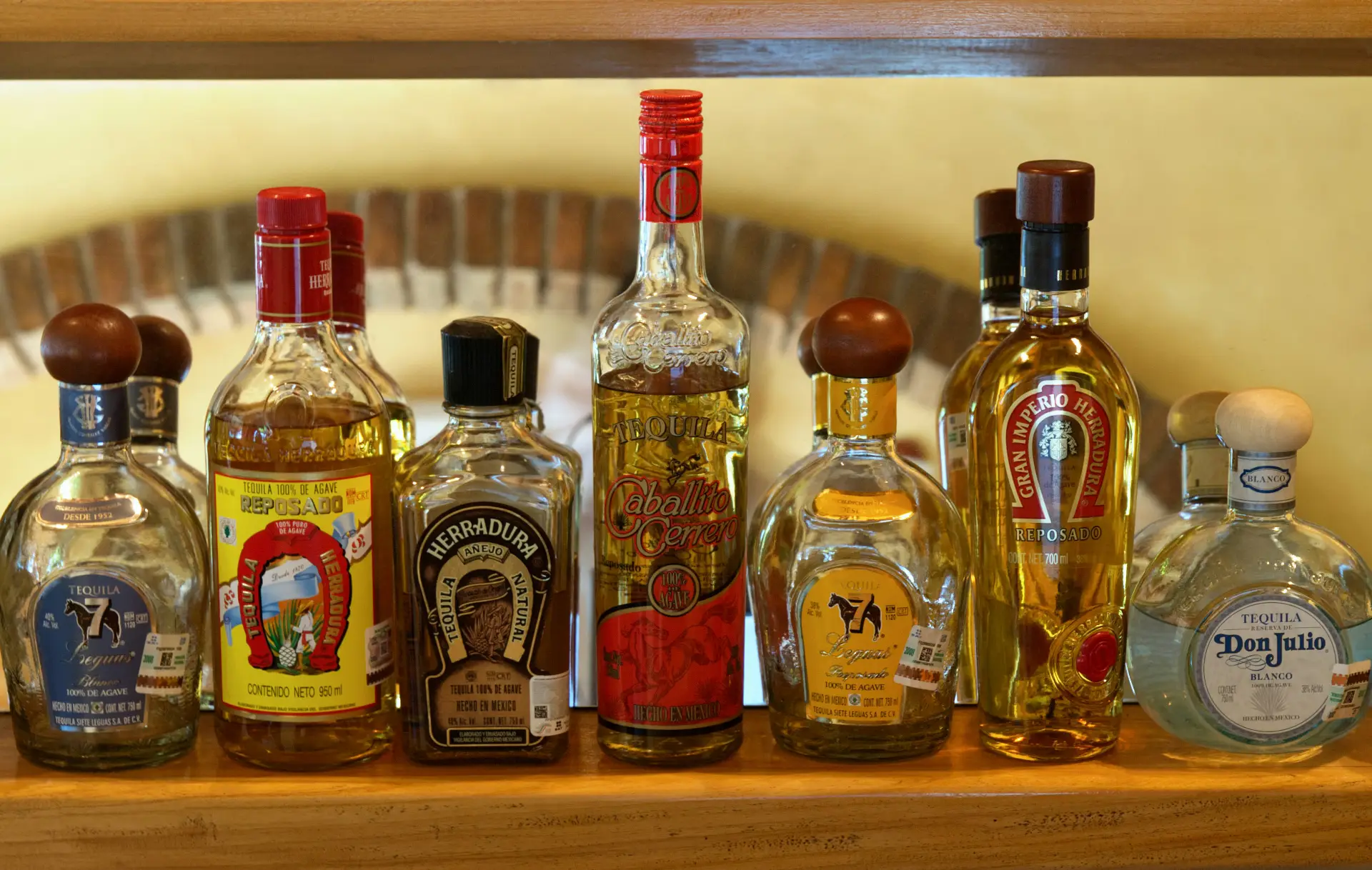 Different bottles of tequila with varying degrees of golden hues